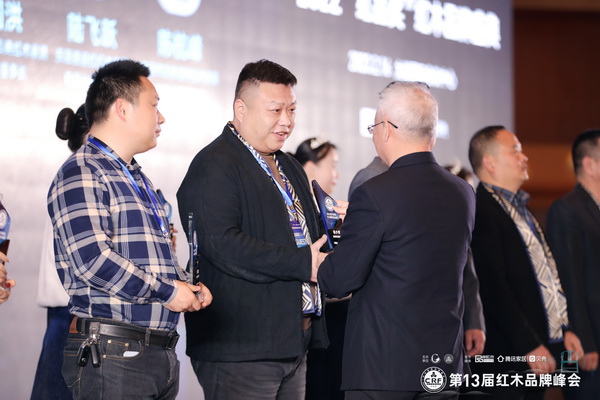 富雅家居董事长杨少辉（左二）领取“2022红木家具十大风云企业家”奖杯